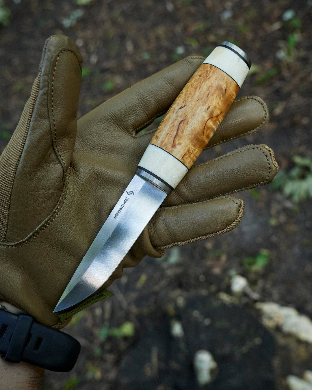 The hand made puukko, n690 blade, curly birch/antler handle, leather sheath.